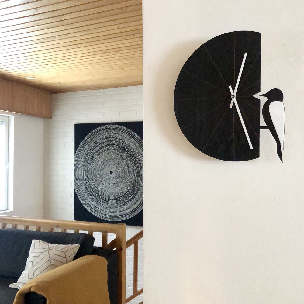 Musta Tikka seinäkello olohuoneen seinälla sopii hyvin skandinaaviseen sisustukseen, The Finland Shop